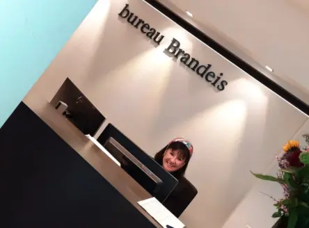 Receptioniste Regina werkt bij bureau Brandeis